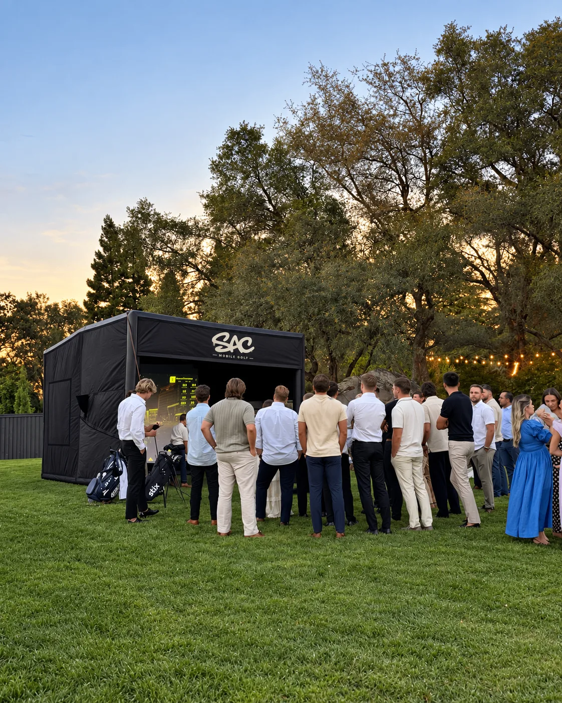 Guests gathered around the Sac Mobile Golf simulator at an outdoor event